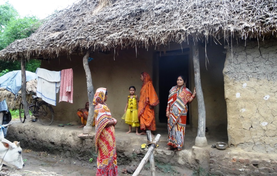 Women standing under the hut