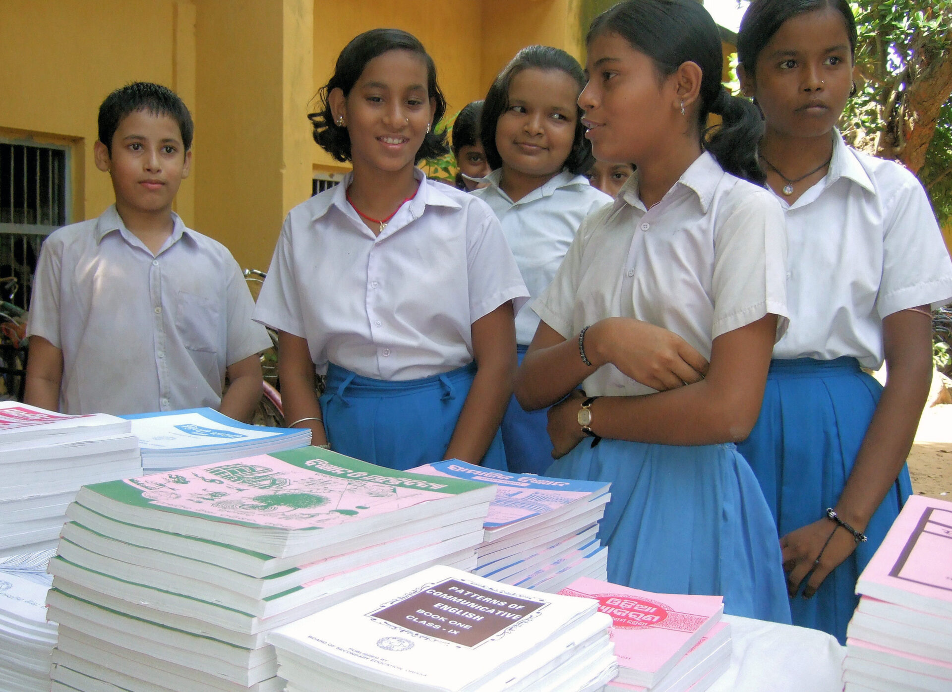 A group of children standing next to books.
