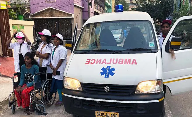 A ambulance with people in front of it.