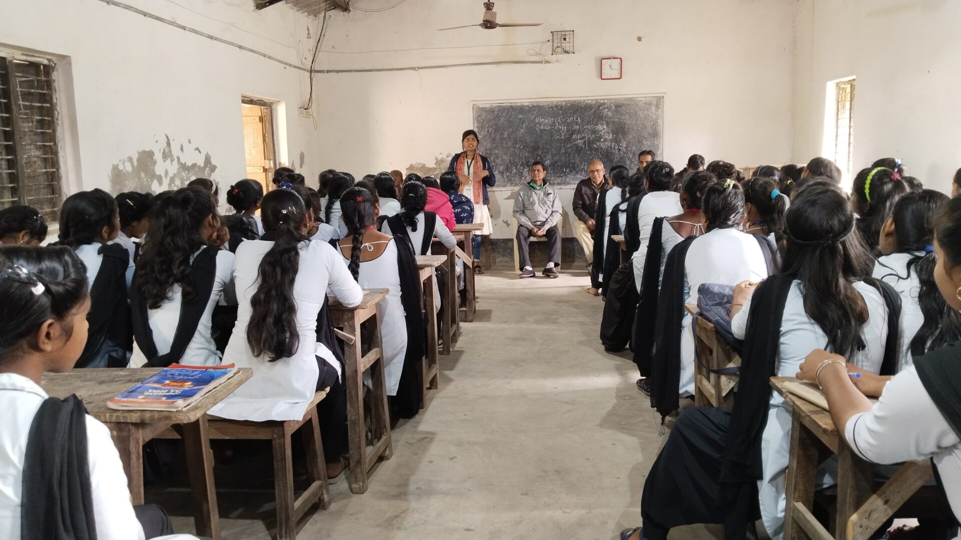 A teacher addressing a classroom full of attentive students.
