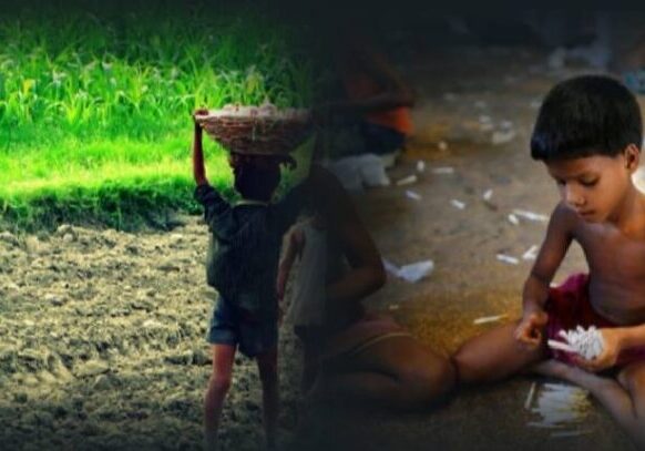 A person holding something in their hand while sitting on the ground.