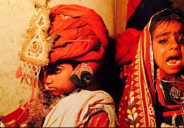 A man in red turban and white shirt.