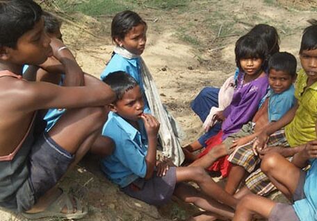 A group of children sitting on the ground.